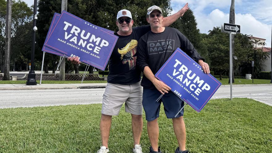 Dos simpatizantes del expresidente y candidato republicano Donald Trump muestran carteles de apoyo al candidato, este martes en Palm Beach, Florida (Estados Unidos).