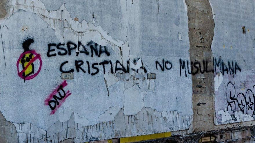 Pintada en los aledaños del centro de menores de Santa Cruz, en un solar frente a un cartel de Vox contra las instalaciones / Carlos Trenor