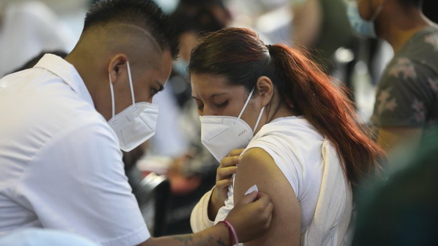 Fotografía de archivo del 24 de agosto de 2021 que muestra a un vacunador tras aplicar una dosis de la vacuna contra la covid-19 a una mujer, en Ciudad de México. EFE/ Sáshenka Gutiérrez ARCHIVO