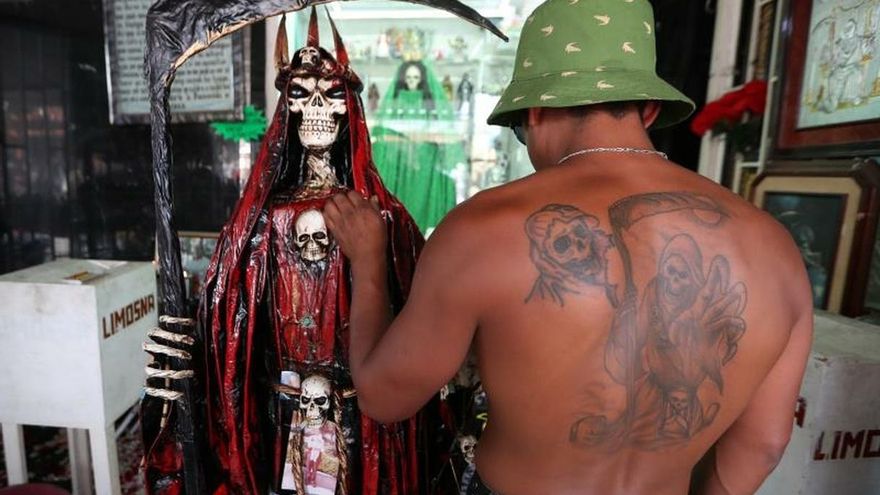 Un seguidor con un tatuaje de la Santa Muerte en su espalda acude este miércoles al altar de la figura en el popular Barrio de Tepito, en la Ciudad de México (México).