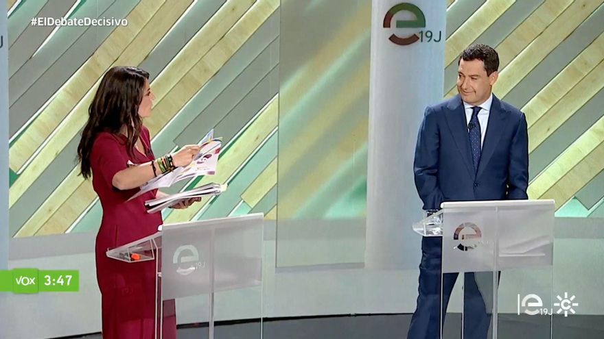 Olona mostrándole libros de texto a Juanma Moreno