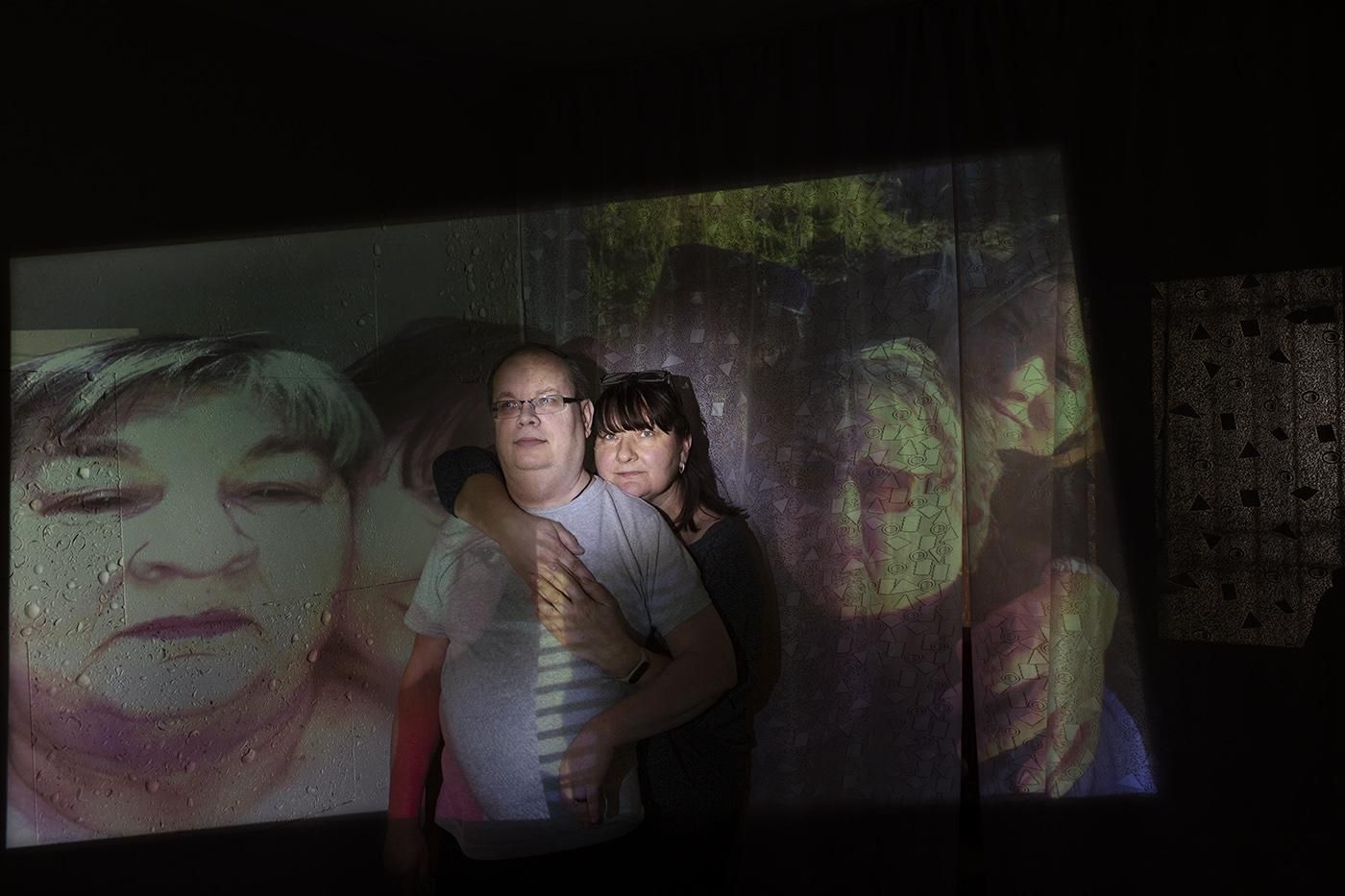 Irina y su marido, discapacitado, con imágenes de su madre de fondo.