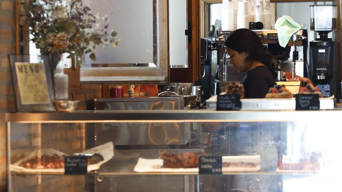 Una camarera trabaja durante su jornada laboral en la barra de una cafetería de la capital madrileña.