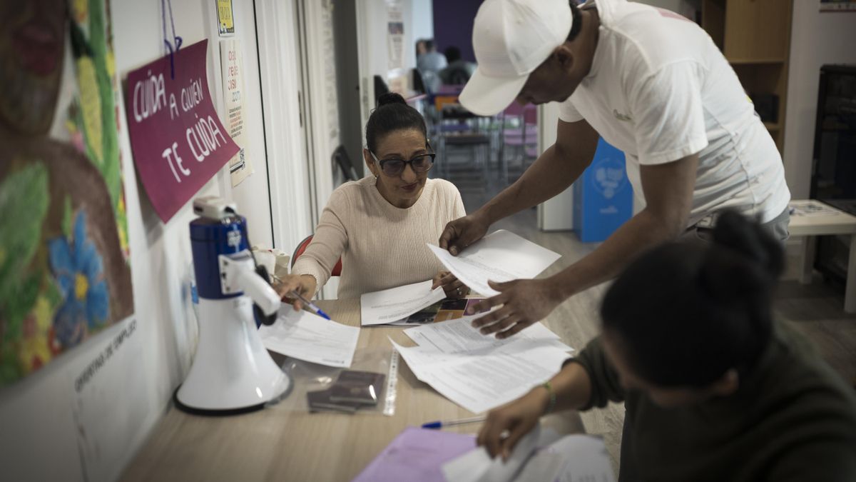 Varias personas rellenan sus datos tras ser atendidos por la ONG Sedoac para conseguir el informe de vulnerabilidad