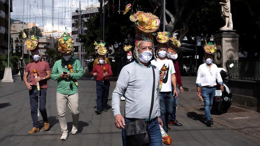 Un grupo de hombres con vistosos tocados pasea por las calles de la capital tinerfeña