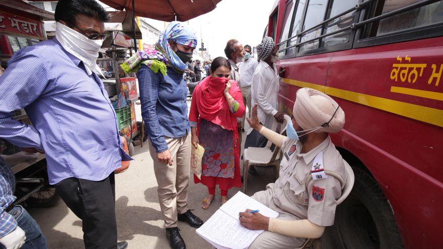 Amritsar (India), 25/03/2021.- An Indian police officer (R), notes down details of defaulters who were not wearing face masks before testing them for Covid19 disease, in a mobile van set up to test random people who are not wearing the mandatory face masks, in Amritsar, India, 25 March 2021. The state government has asked people to follow certain guidelines, including imposing of night curfew in wake of rising Covid19 cases in Punjab. A year ago, the Indian prime Minister Narendra Modi declared a 21-day lockdown across India which started on 24 March, in a bid to slow down the spread of the ongoing pandemic of the COVID-19 disease. EFE/EPA/RAMINDER PAL SINGH