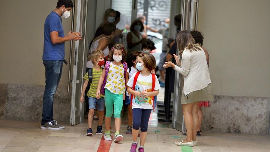 Los maestros reciben con aplausos a los niños en el colegio Balmes de València en el primer día de cole.