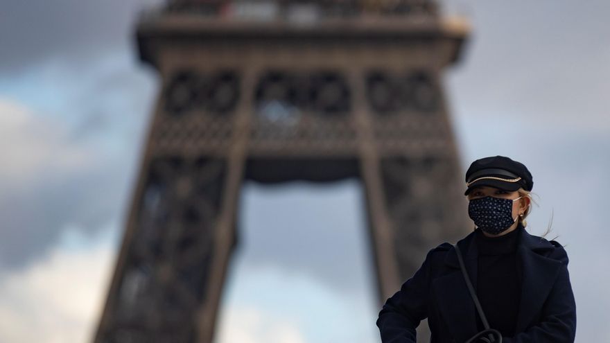 Una parisina con mascarilla pasa frente a la Torre Eiffel en París, Francia, el 10 de diciembre. EFE/EPA/IAN LANGSDON