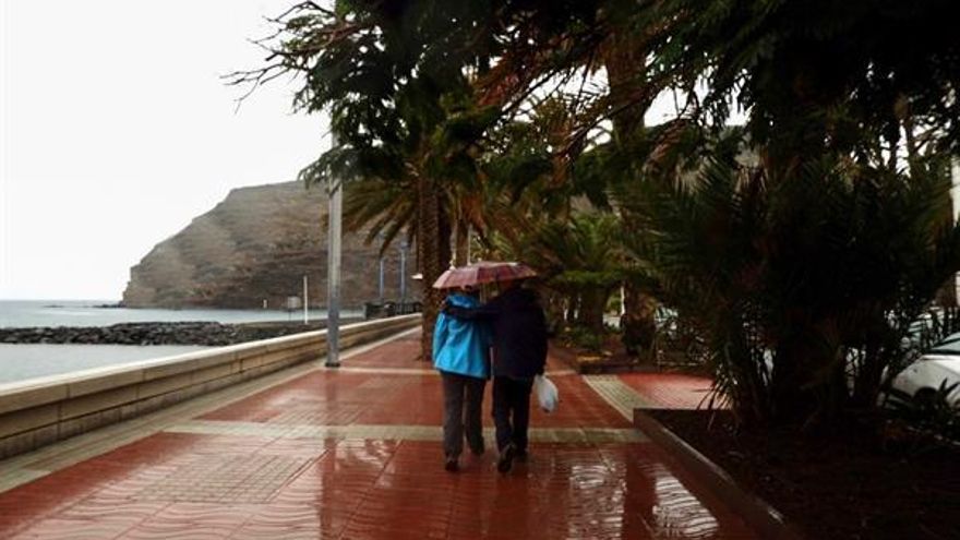 Una pareja pasea bajo la lluvia en San Sebastián de La Gomera. (EFE/ Candela Fernández)