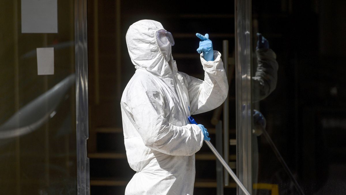 Un hombre desinfecta el portal del edificio de Santander en la calle Nicolás Salmerón, donde los vecinos llevan más de diez días confinados en sus domicilios tras detectarse un brote de coronavirus. EFE/Pedro Puente Hoyos/Archivo