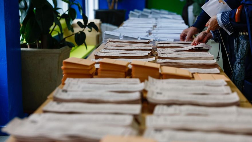 Votantes ejercen su derecho al voto en un colegio electoral.