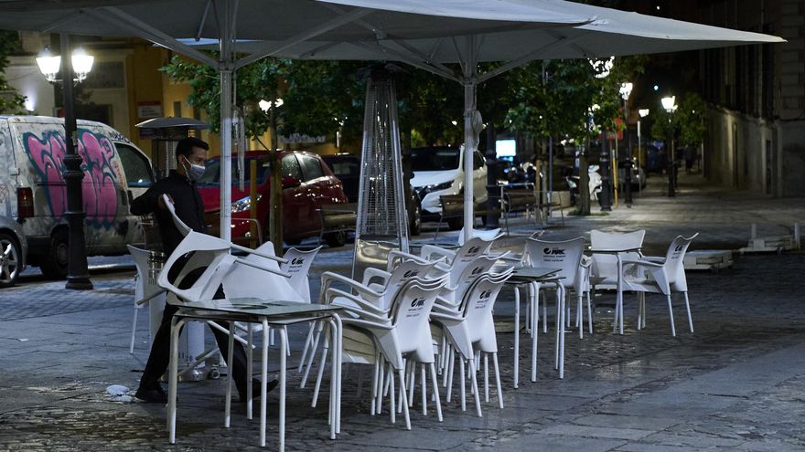 Una persona recoge la terraza de una cafetería en Madrid durante la primera jornada en la que se permite el cierre a la 01.00 en hostelería y recintos culturales, a 31 de mayo de 2021, en Madrid (España). La ampliación de horarios hasta la 01.00 horas en bares, restaurantes, cines, teatros, auditorios y locales de la Comunidad de Madrid entra en vigor este lunes. En concreto, en lo referente al sector de la hostelería y de la restauración, la hora de cierre será a la 01.00 pero deberán de dejar de admitir clientes a partir de las 00.00 horas.