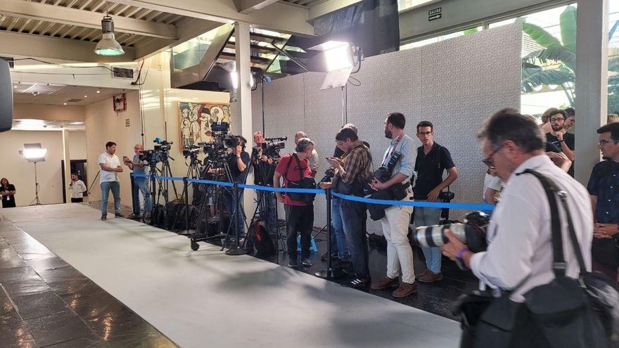 Pasillo de entrada con los periodistas gráficos a la espera de la llegada de los candidatos