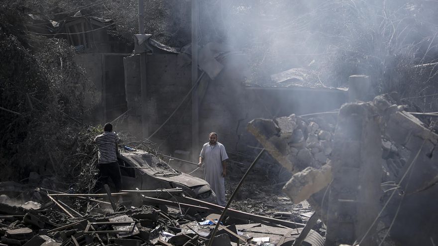 Dos hombres buscan a sus familiares en los restos de una casa derruida por un bombardeo israelí en Gaza.
