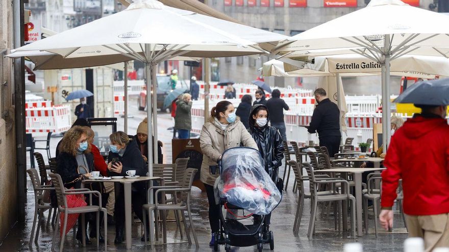 Varias personas en la terraza de un bar un día antes del cierre de la hostelería, en Vigo, Galicia (España)