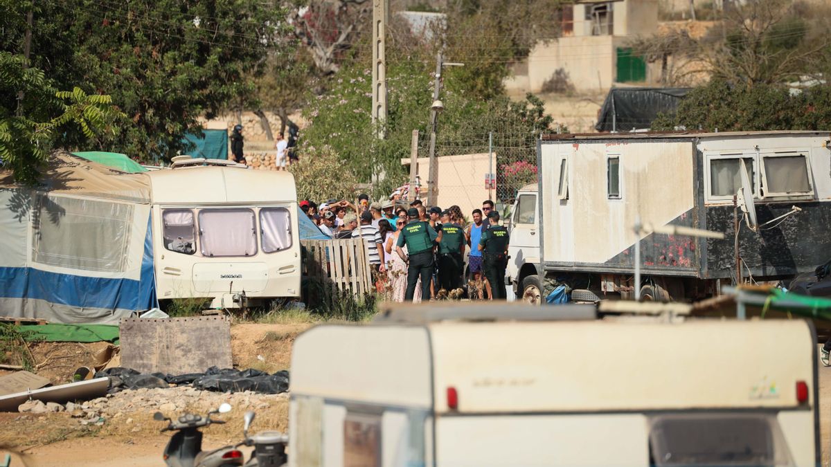 Agentes de la Benemérita dialogan con los desahuciados entre las caravanas en las que vivían en un poblado chabolista de la isla.