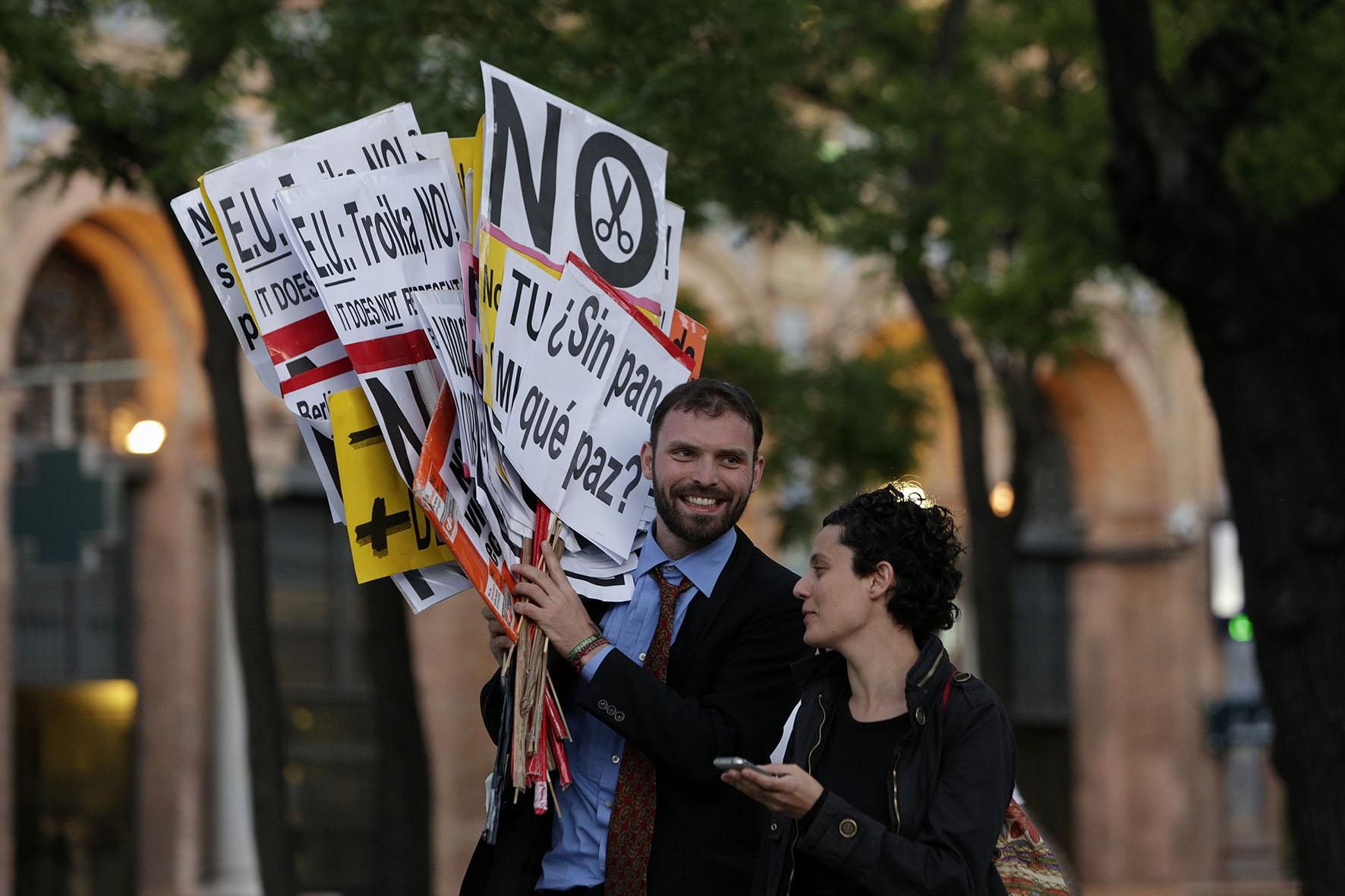 Dos asistentes a la manifestación contra la troika, del 1 de junio en Madrid, portan carteles (Olmo Calvo)