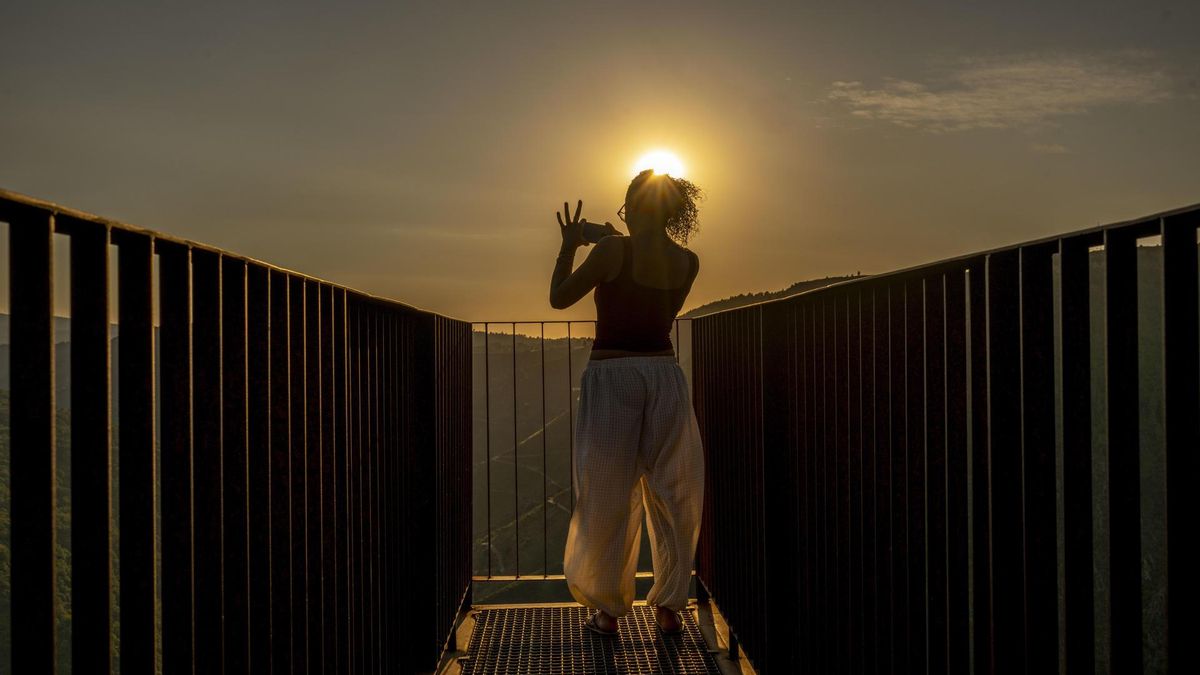 Una mujer toma fotografías este martes del atardecer y del Cañón del río Sil desde el Mirador de Matacás, en Castro Caldelas (Ourense).