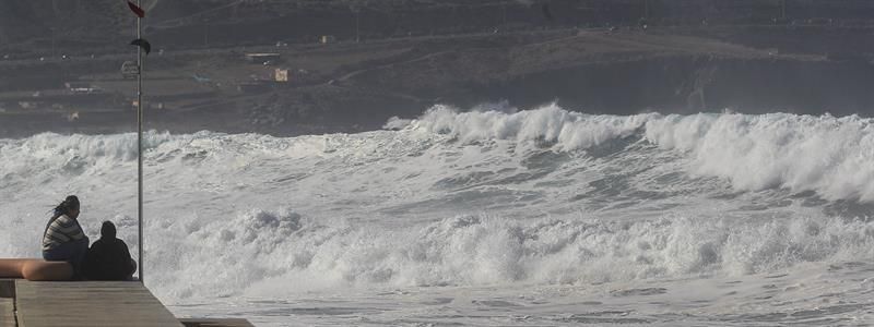 Varias personas observan el oleaje en el paseo de la playa de Las Canteras en Las Palmas de Gran Canaria. EFE/Elvira Urquijo A.