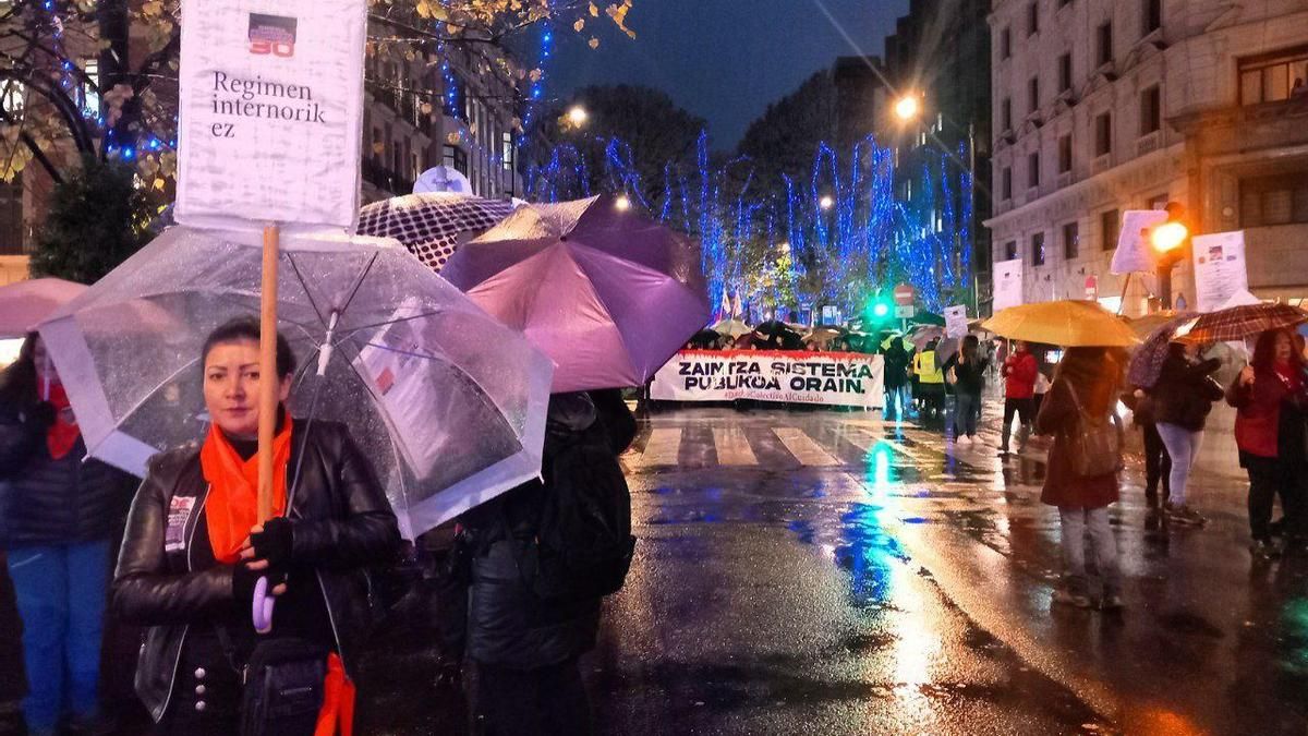 Una trabajadora del hogar con un cartel en euskera que dice "No al régimen interno" de las trabajadoras de su sector durante la manifestación feminista de Euskadi y Navarra