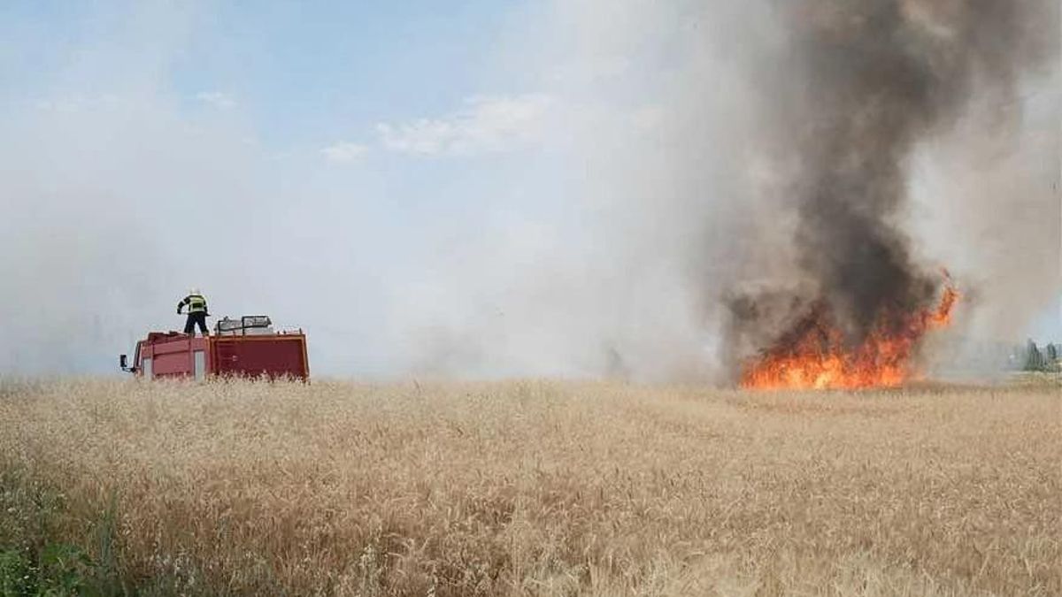 Bomberos tratando de apagar un vehículo agrícola incendiado en Aragón.