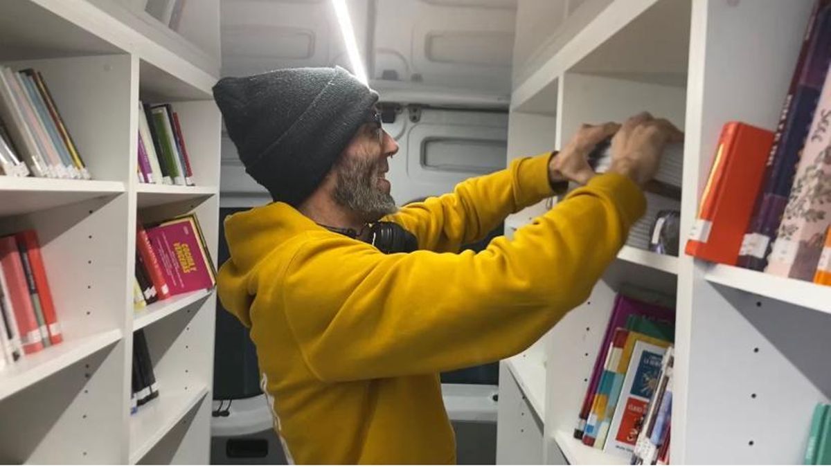 El bibliotecario Diego M. Continente coloca los libros en las estanterías de Biblioteca Nómada
